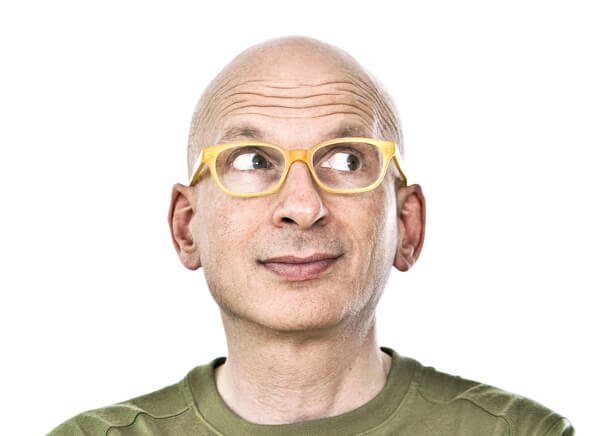 Profile image of author Seth Godin wearing yellow glasses and looking upward.